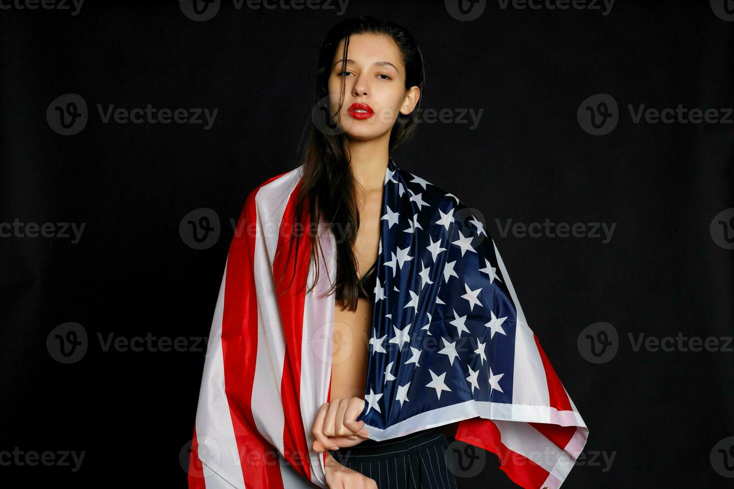 retrato hembra atleta envuelto en americano bandera en contra negro antecedentes foto