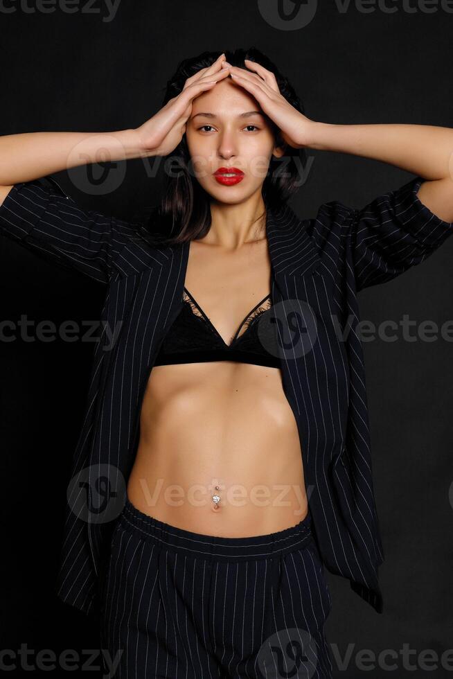 Portrait female athlete wrapped in American Flag against black background photo