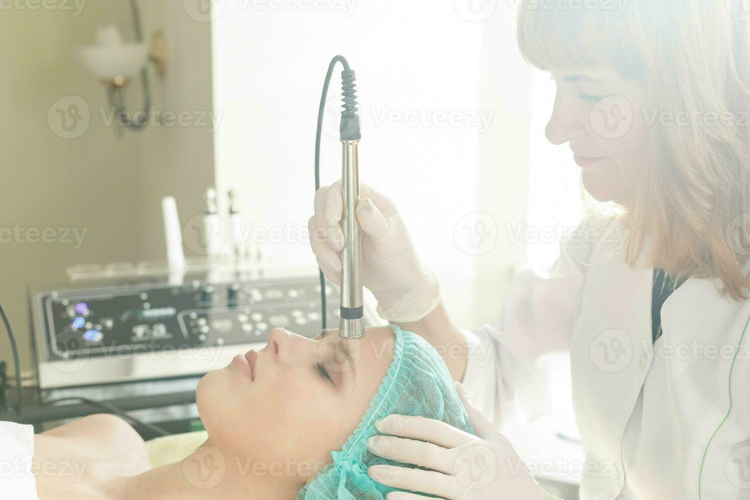 Cosmetologist makes the procedure microcurrent therapy beauty salon photo