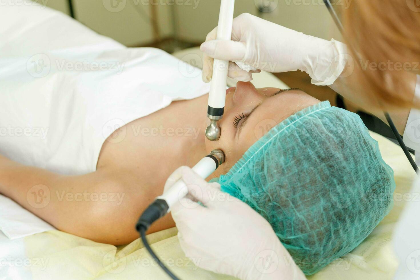 Cosmetologist makes the procedure microcurrent therapy beauty salon photo