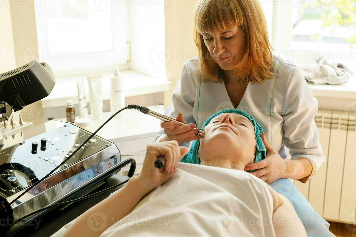 Cosmetologist makes the procedure microcurrent therapy in a beauty salon photo