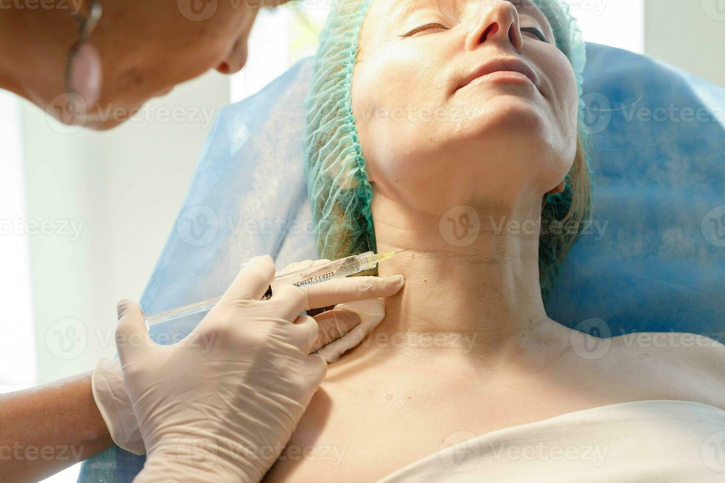 Doctor beautician makes injections in the forehead for patient. photo