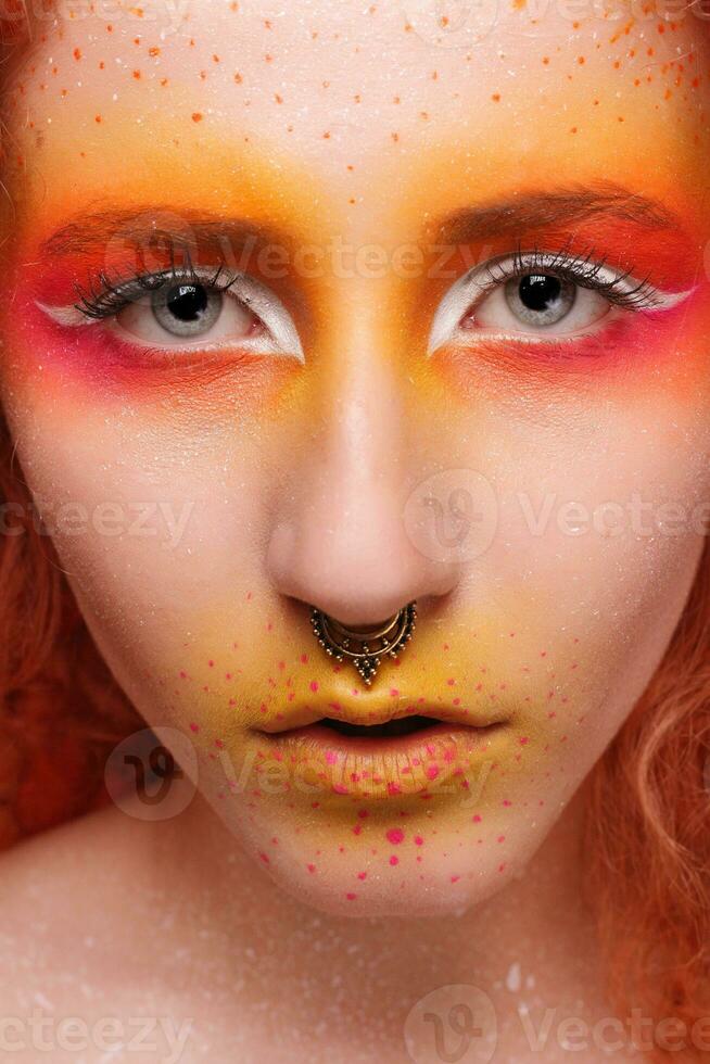 Portrait of the bright beautiful girl with art colorful painting make-up photo