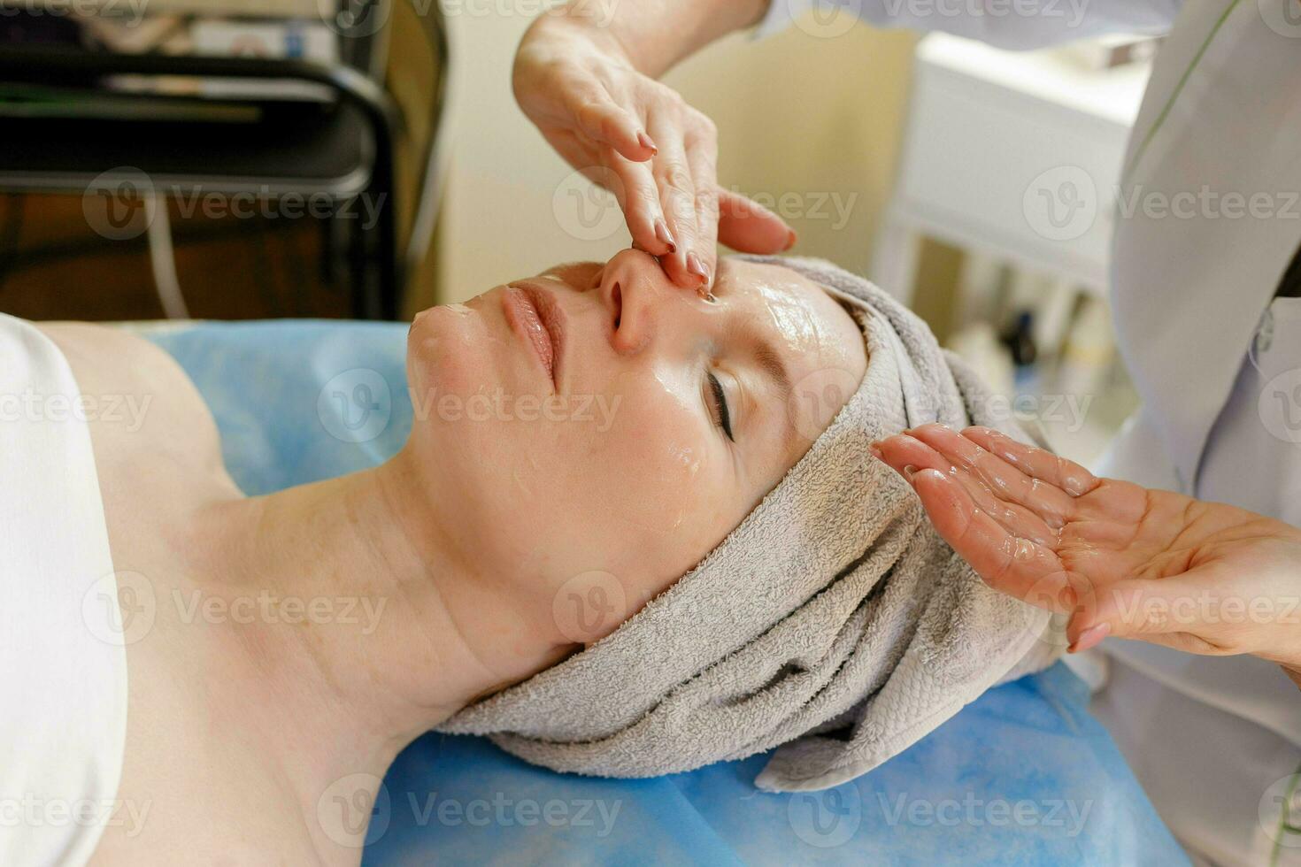 hermosa joven mujer recepción facial masaje con cerrado ojos en un spa salón foto