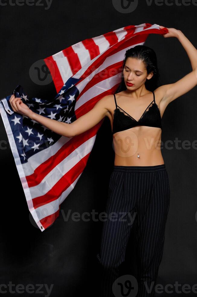 retrato hembra atleta envuelto en americano bandera en contra negro antecedentes foto