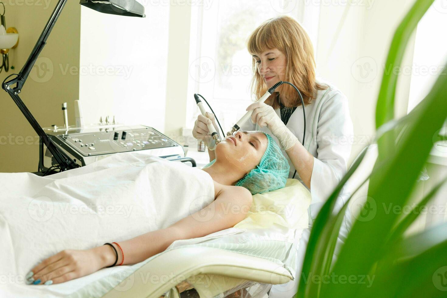 Cosmetologist makes the procedure microcurrent therapy beauty salon photo