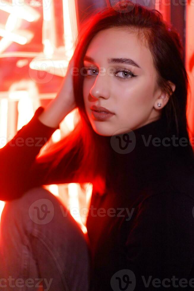 Portrait of a girl on the background of a neon sign of a shop window photo