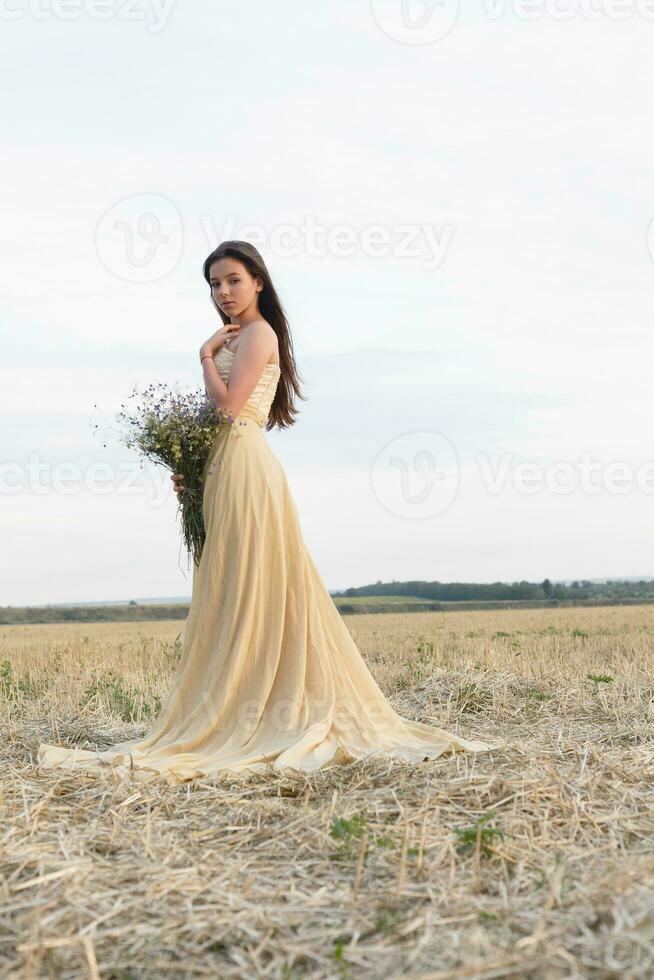 woman walking in golden dried grass field. photo