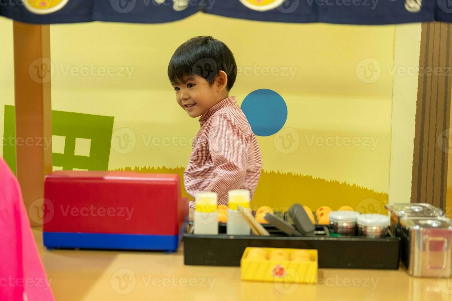 Little Asian boy playing chef serving food photo