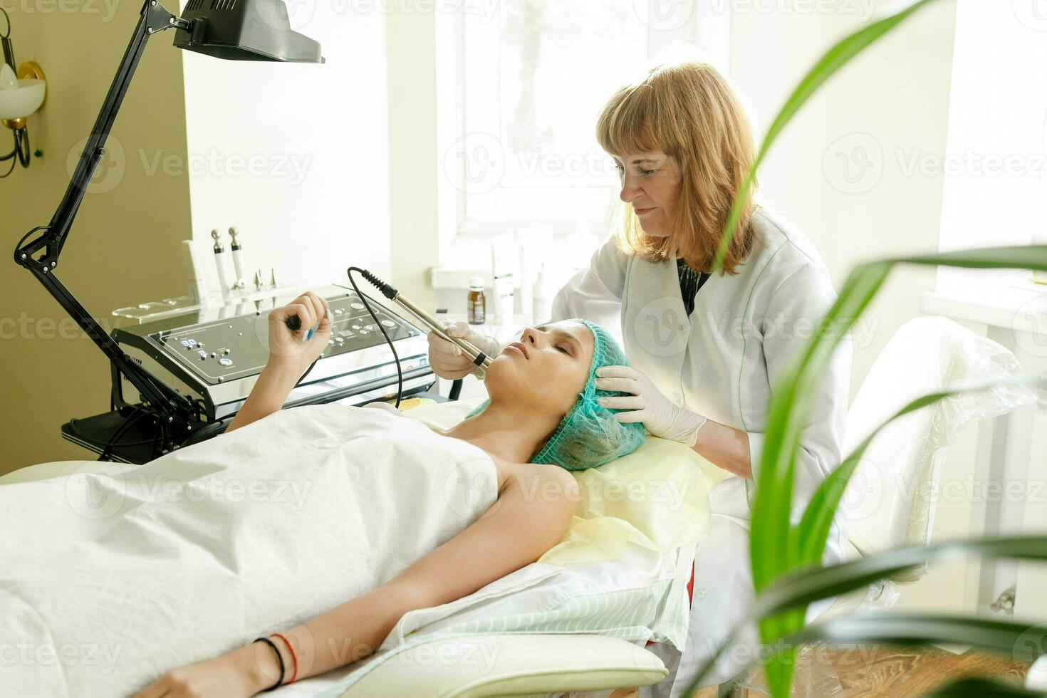 Cosmetologist makes the procedure microcurrent therapy beauty salon photo