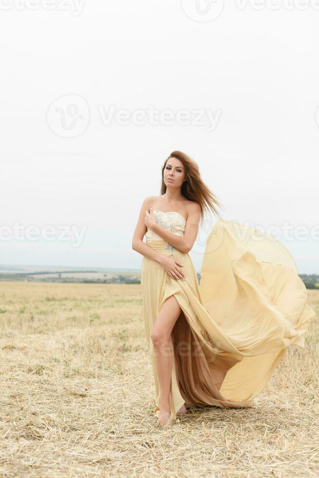 woman walking in golden dried grass field. photo