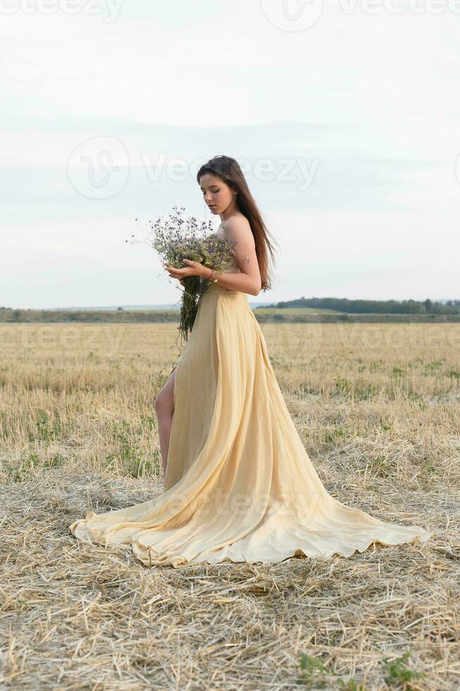 woman walking in golden dried grass field. photo
