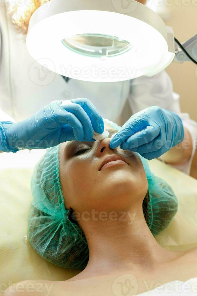 Cosmetologist makes the procedure microcurrent therapy beauty salon photo