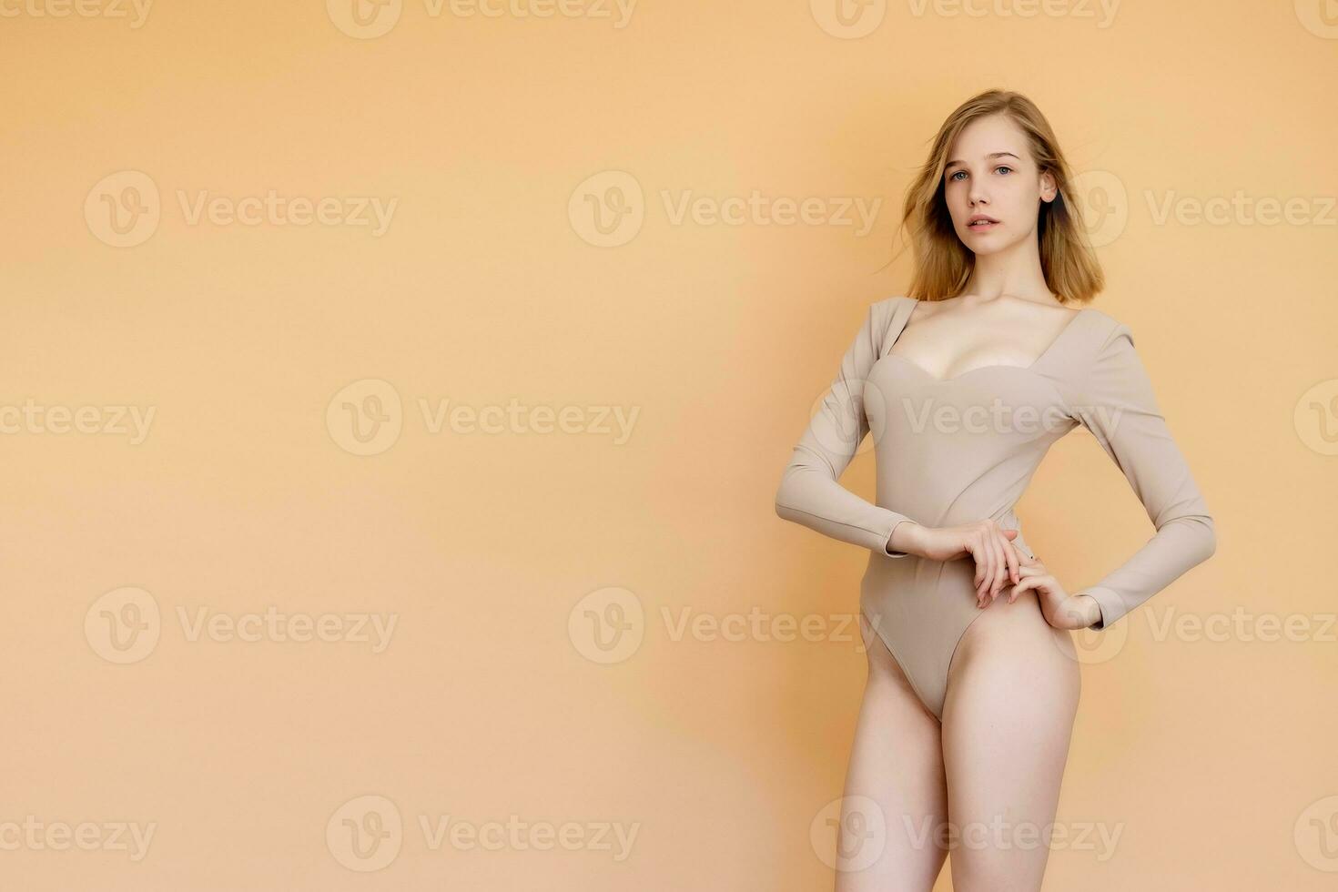Portrait of a smiling young blonde woman wearing beige swimsuit photo