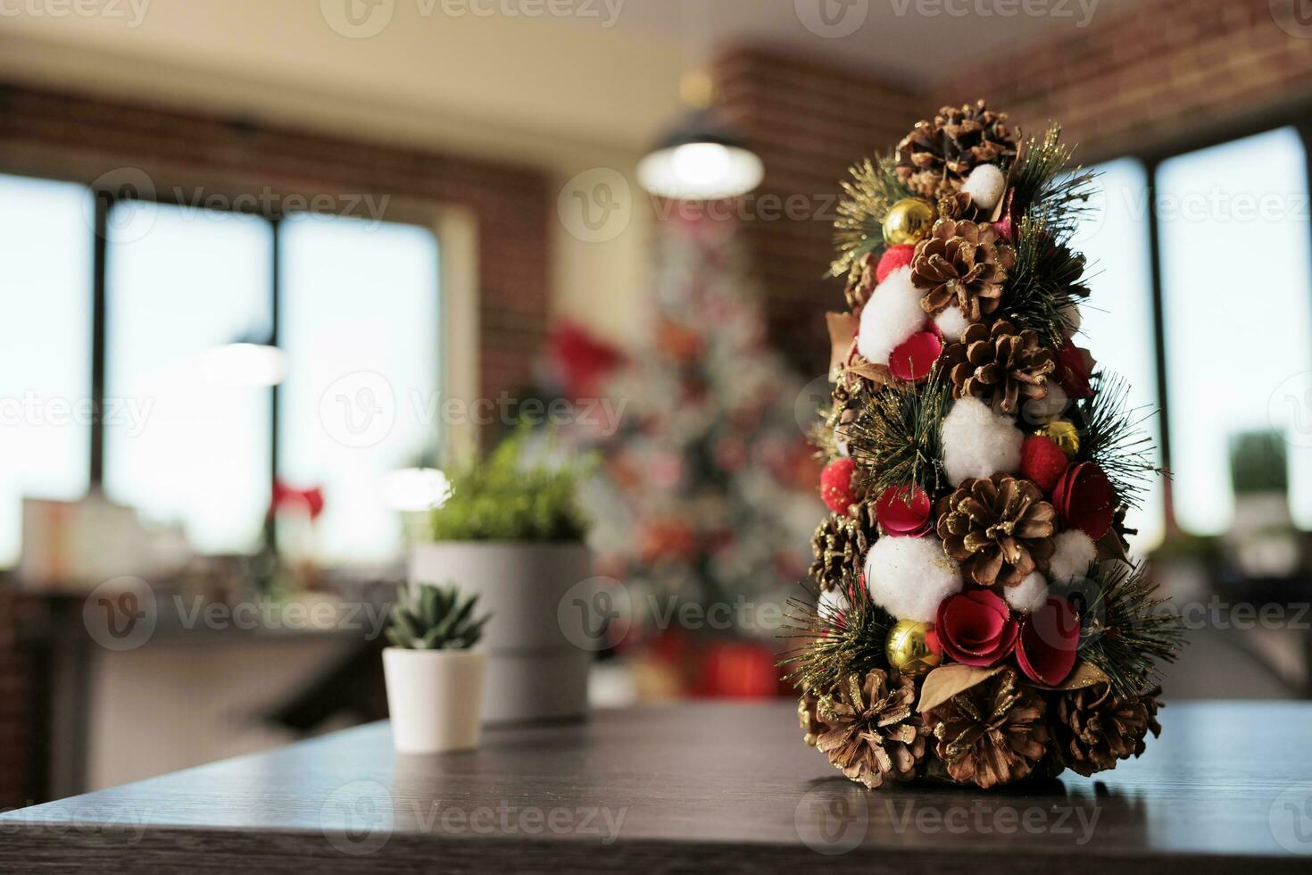 Decorated artificial christmas tree with ornaments and houseplant in festive office workplace closeup. Winter celebration season adornments in corporate workspace selective focus photo
