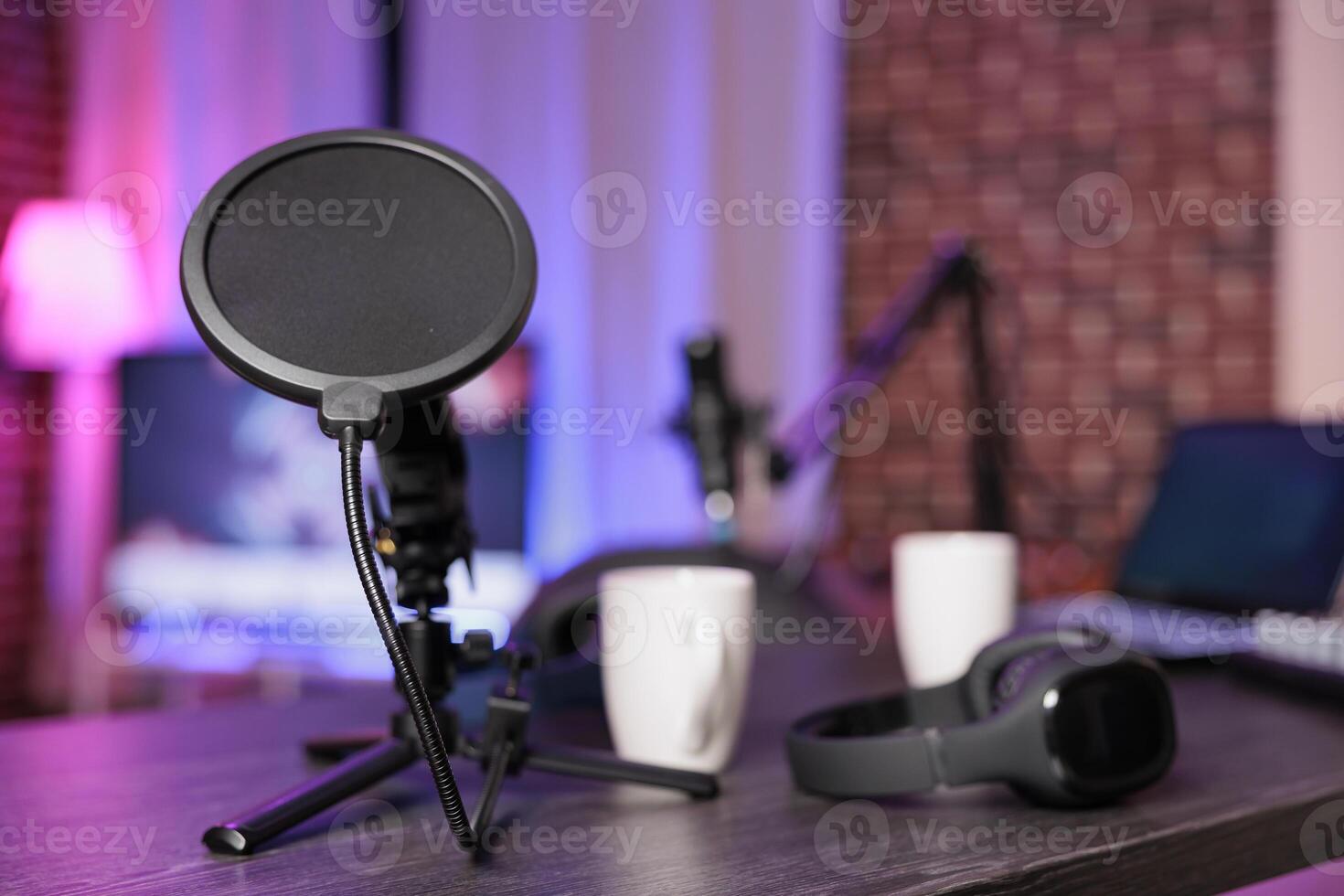 Close up shot of podcast microphone used to record internet show for online livestreaming channel. Streaming sound capturing and recording podcasting tool in empty living room with neon lights photo