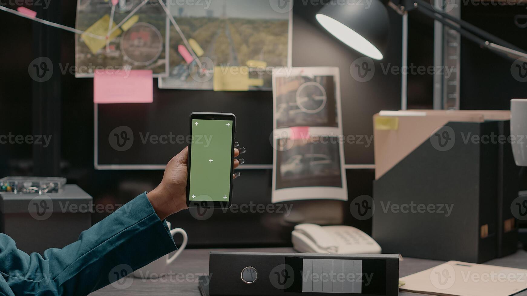 Team of police officers examining greenscreen display in private investigation room, working with chroma key template and mockup. Private detectives looking at copyspace screen. photo