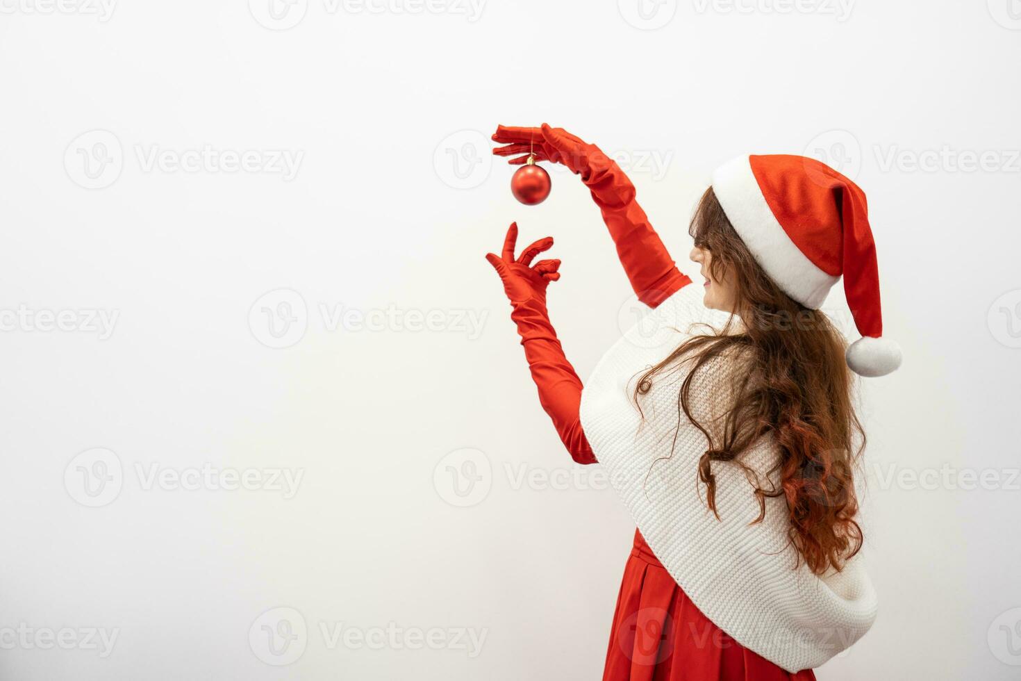 Smiling woman with Christmas ball on white background is moment comfort and anticipation festive miracles. Red ball in hands attractive woman gives New Year's touch to any project or congratulations. photo