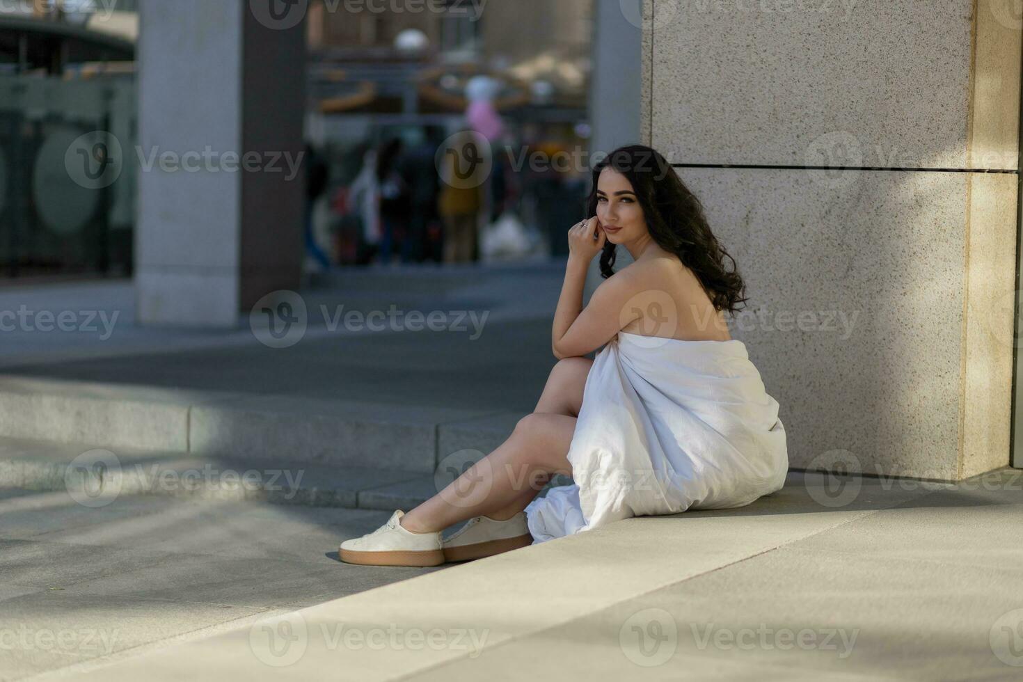 Young woman through the evening streets wrapped in a blanket. photo