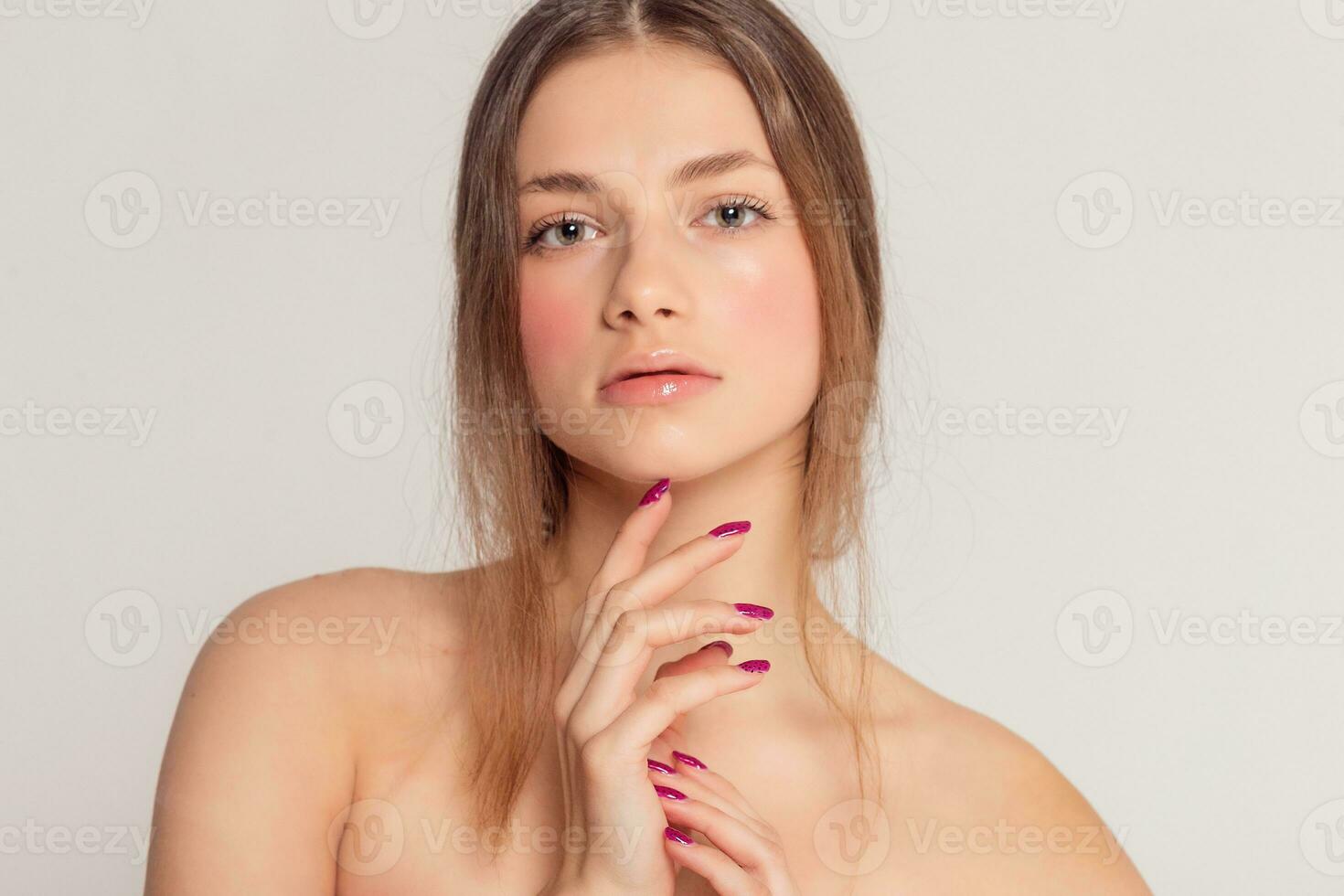 Beautiful Young Woman with Clean Fresh Skin touch own face photo