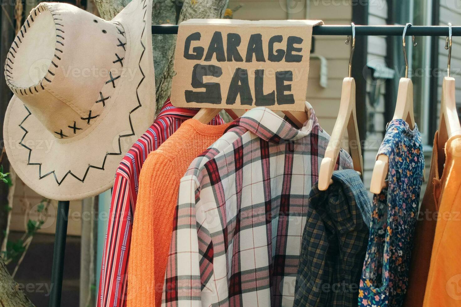 Garage sale. Used clothes on floor hanger outdoors. photo