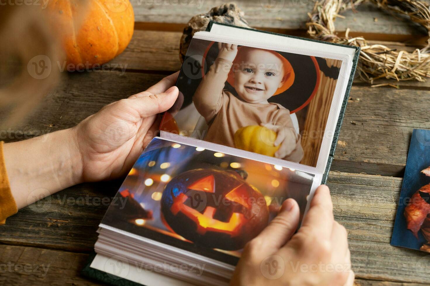 Halloween printed photos in picture album. Person browsing photo album.