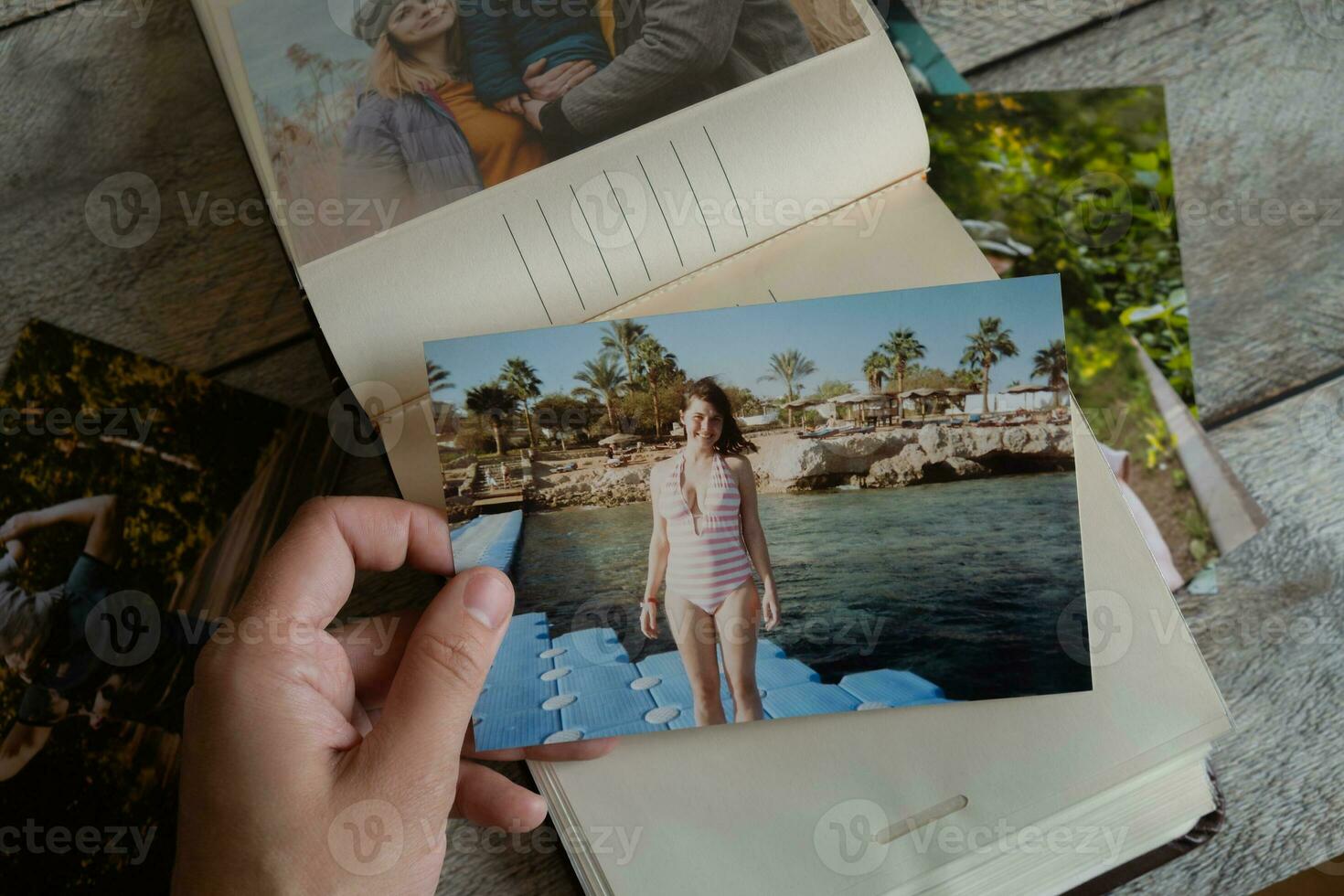 Photo printing concept. Person looks at printed photos in photo album.