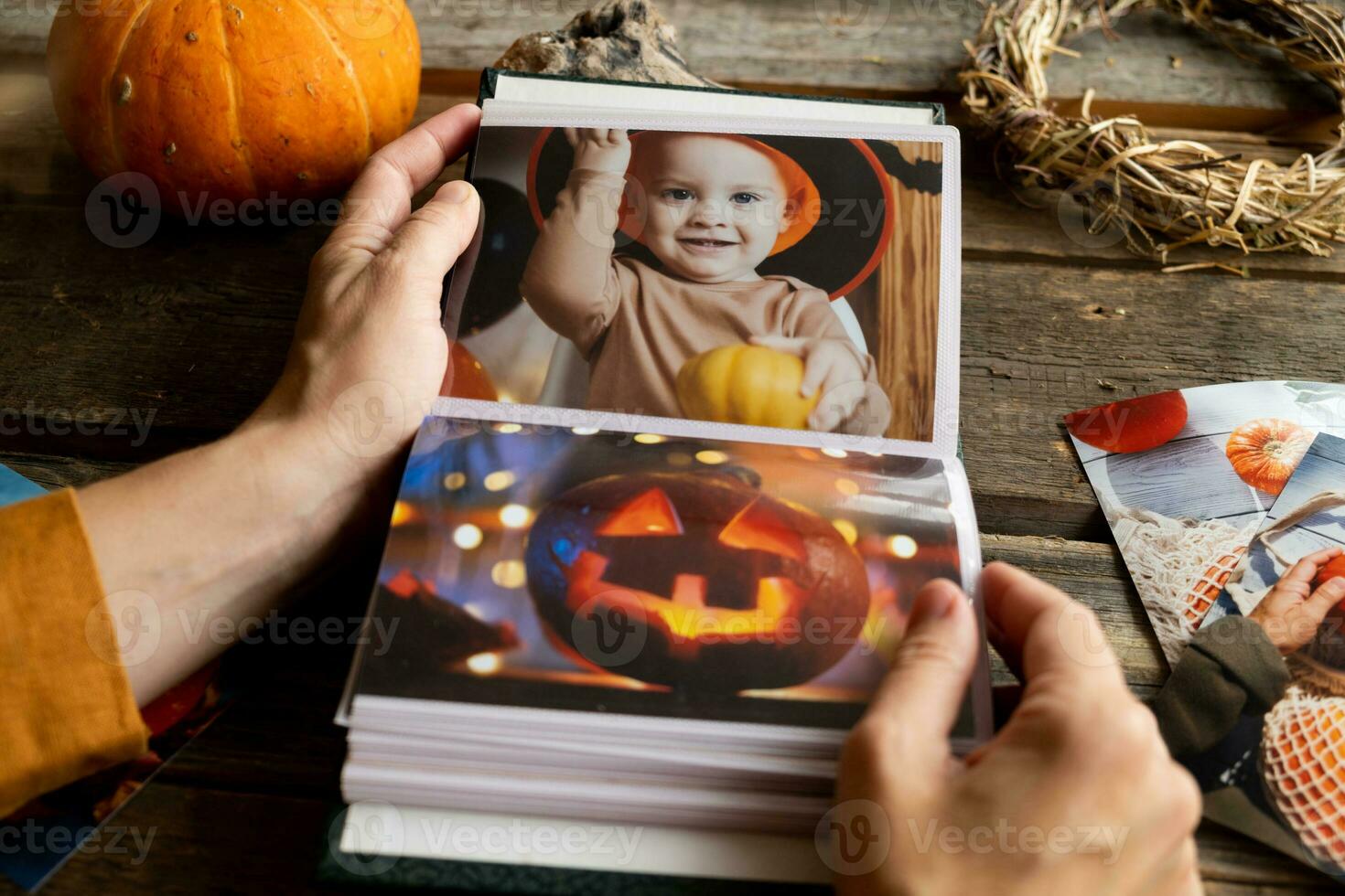 Halloween printed photos in picture album. Female hands browsing photo album.