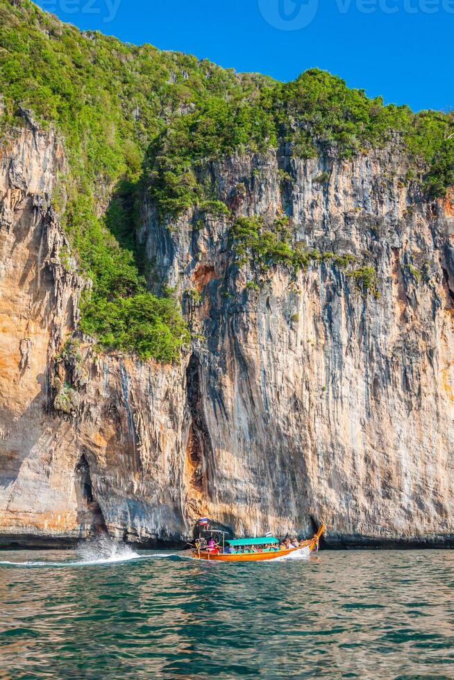 Cliff and the clear sea with a boat near Phi Phi island in south of Thailand photo