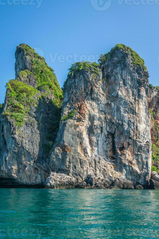 Cliff and the clear sea with a boat near Phi Phi island in south of Thailand photo
