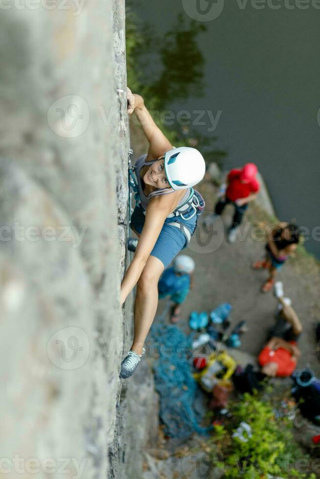 A girl climbs a rock. Woman engaged in extreme sport. photo