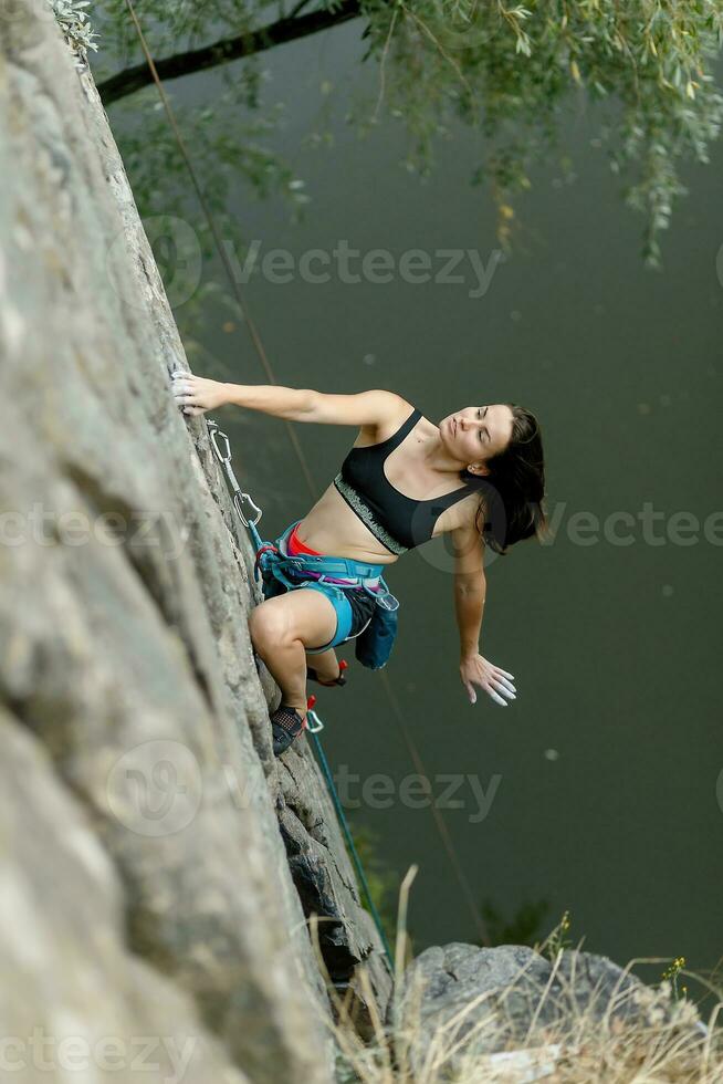 un niña sube un roca. mujer comprometido en extremo deporte. foto