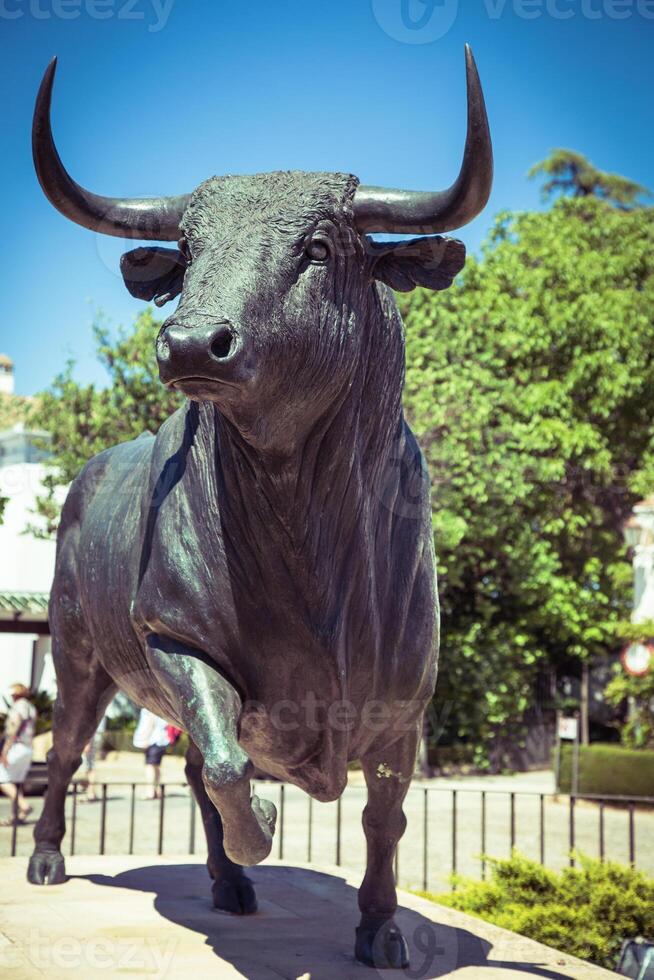 Bull statue in front of the bullfighting arena in Ronda, Spain photo