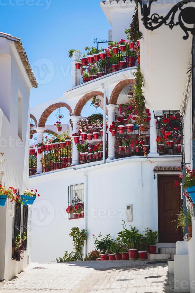 Picturesque street of Mijas with flower pots in facades. Andalusian white village. Costa del Sol. Southern Spain photo