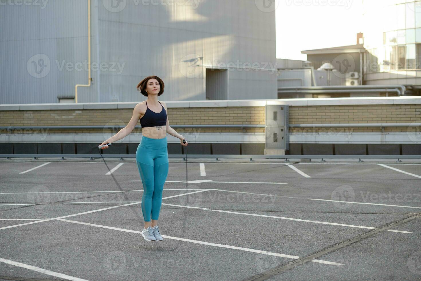 fuerte joven mujer extensión con salto a la comba. foto