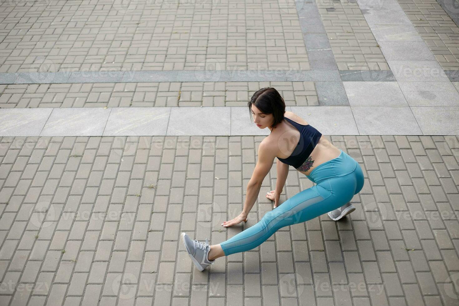 Female runner stretching after a running session in city. photo