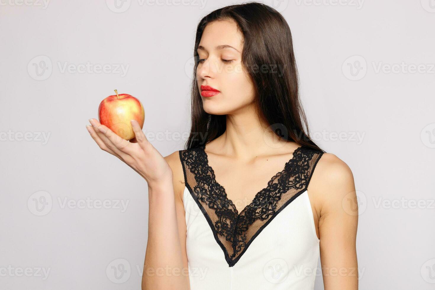 Healthy eating. Woman biting red apple with perfect teeth photo