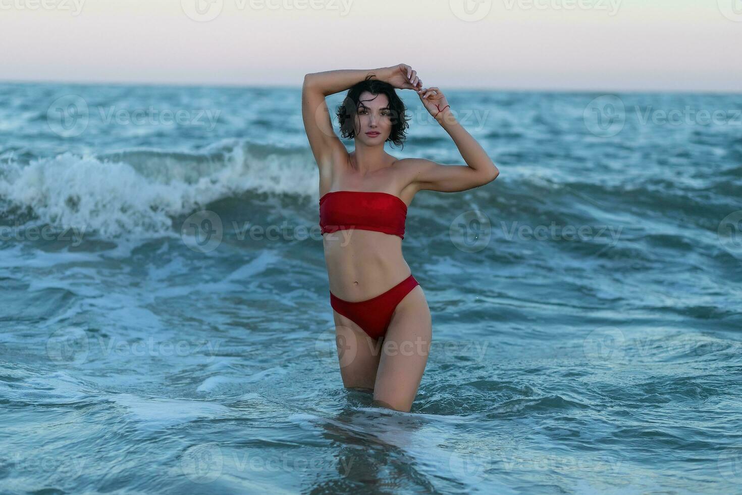 Sexy back of a beautiful woman in red bikini on sea background photo