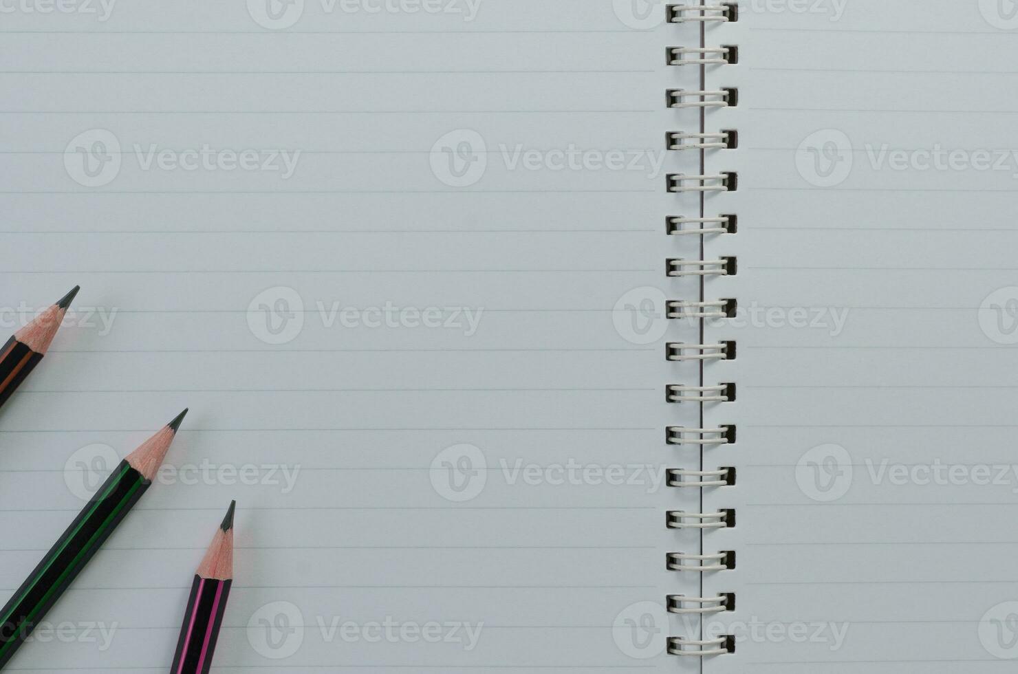 Pencils on Blank Page of Spiral Notebook for Copy Space Background photo