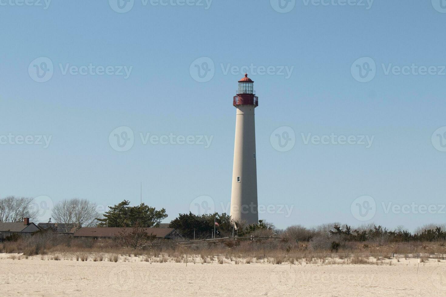 esta es capa mayo punto faro visto desde el playa. el alto blanco estructura con rojo metal sirve como un Faro de seguridad. foto