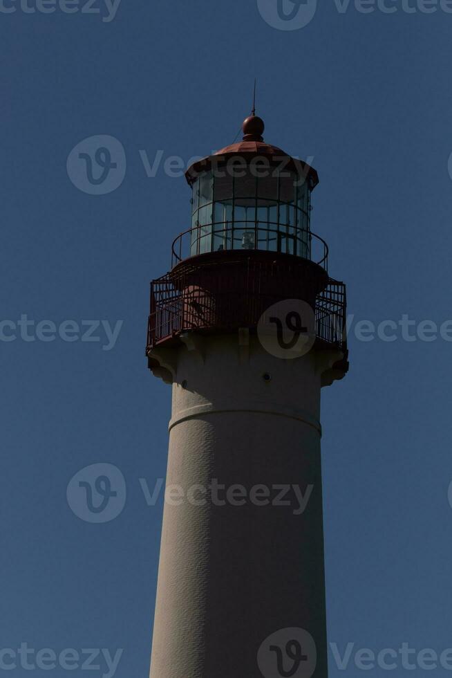 This is the top image of Capy May point lighthouse. The red metal top stands out against the white brick of the tower. photo