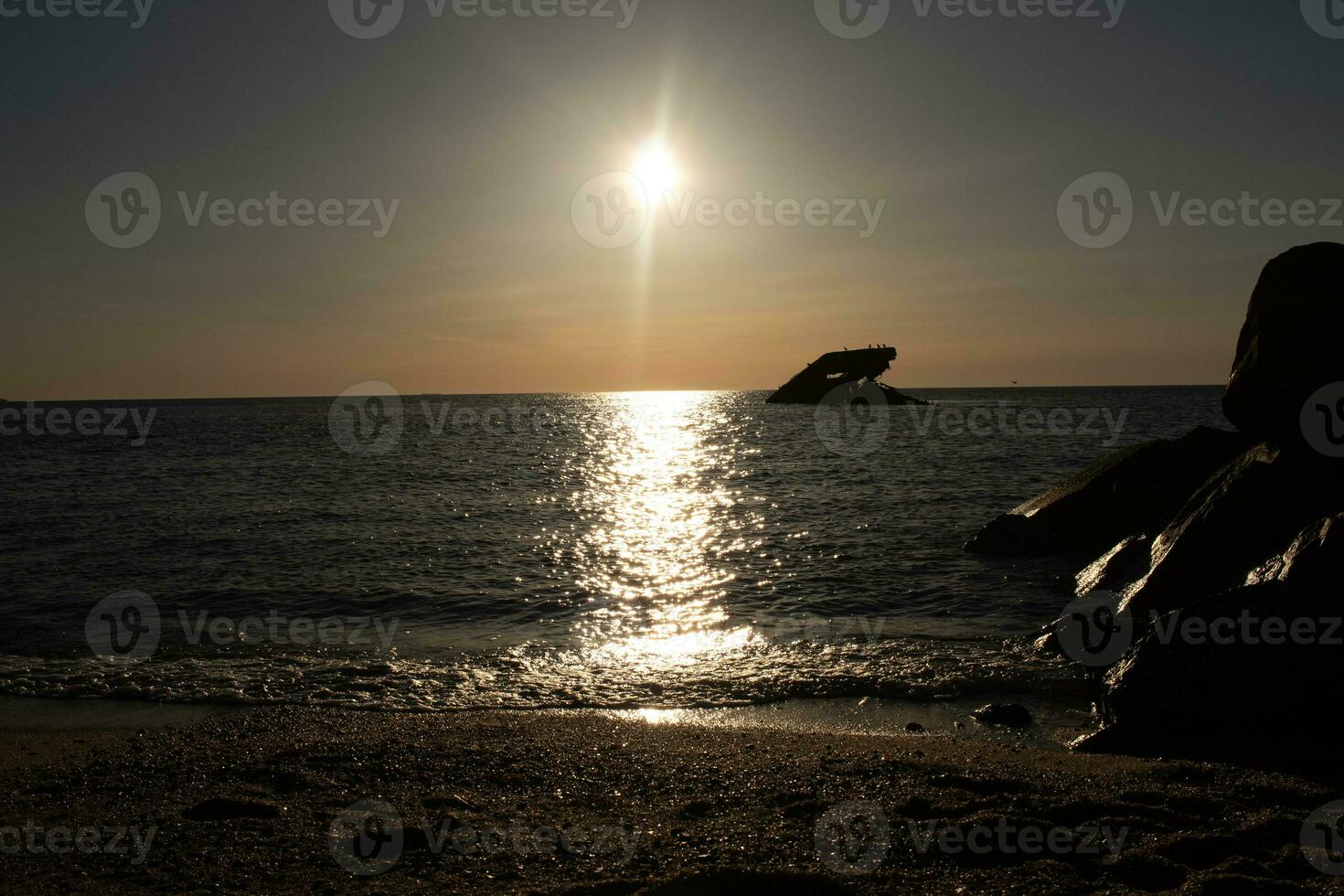 puesta de sol playa en capa mayo nuevo jersey dónde usted lata obtener un genial ver de el Dom yendo abajo a través de el Oceano y el bahía. el reflexión de el Dom en el agua con el hundido Embarcacion mira entonces hermosa. foto