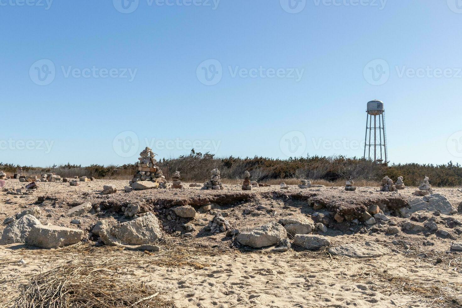 This rocky beach was at Sunset Beach in Cape May New Jersey. This beach is iconic for all the pebbles and rocks that are on it. The sand dunes in the back really add to this image. photo