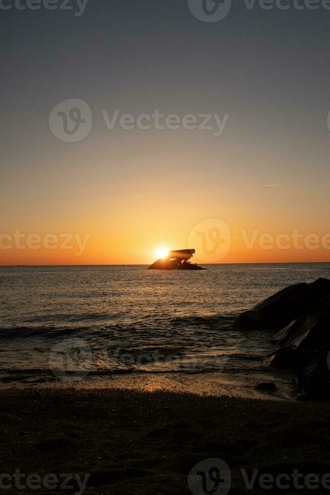 puesta de sol playa en capa mayo nuevo jersey dónde usted lata obtener un genial ver de el Dom yendo abajo a través de el Oceano y el bahía. el reflexión de el Dom en el agua con el hundido Embarcacion mira entonces hermosa. foto