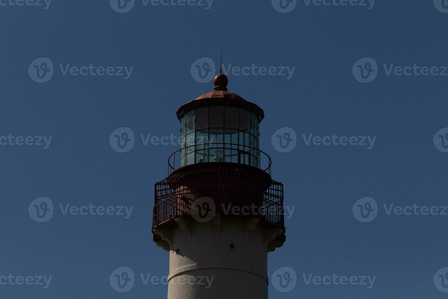 This is the top image of Capy May point lighthouse. The red metal top stands out against the white brick of the tower. photo