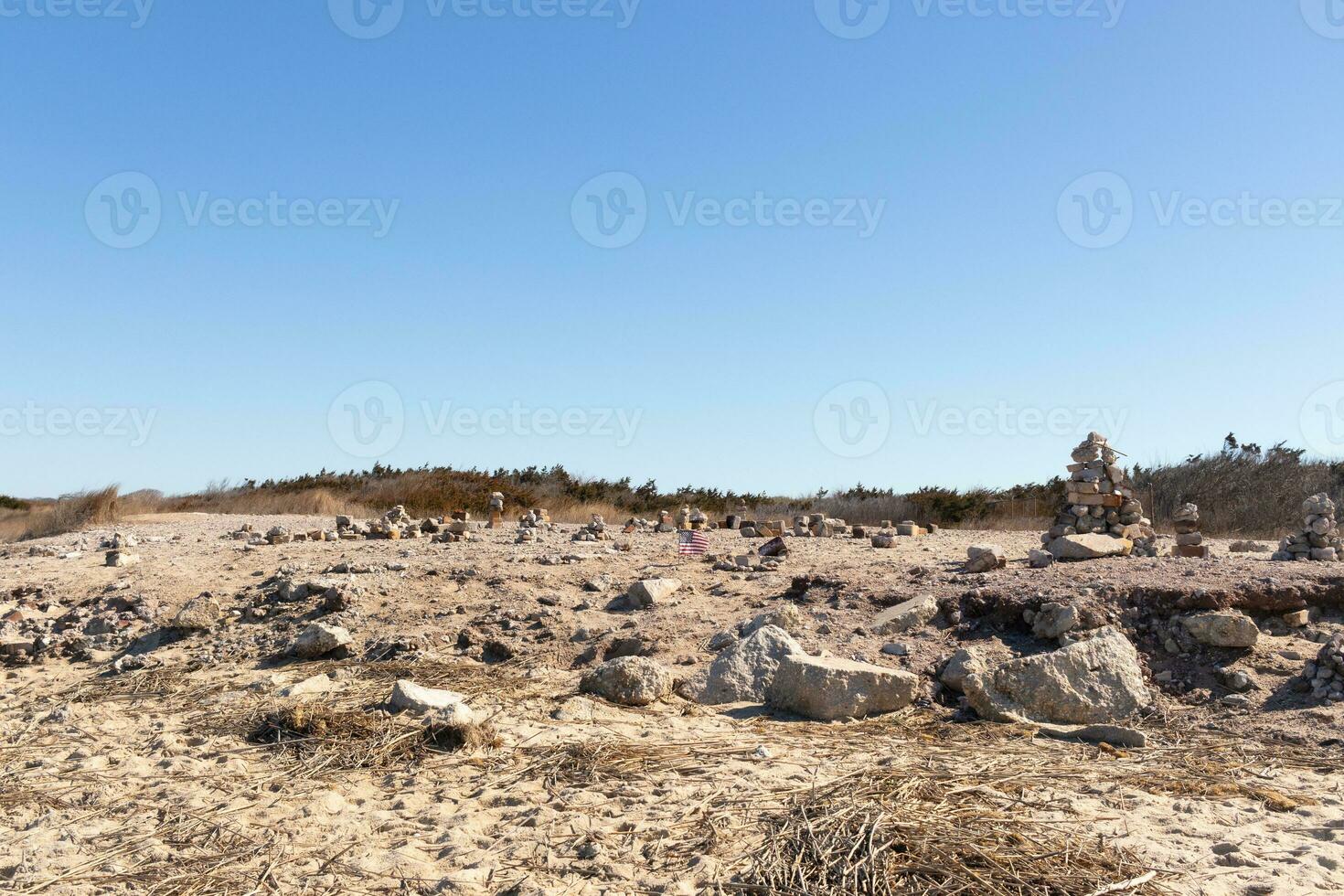 This rocky beach was at Sunset Beach in Cape May New Jersey. This beach is iconic for all the pebbles and rocks that are on it. The sand dunes in the back really add to this image. photo