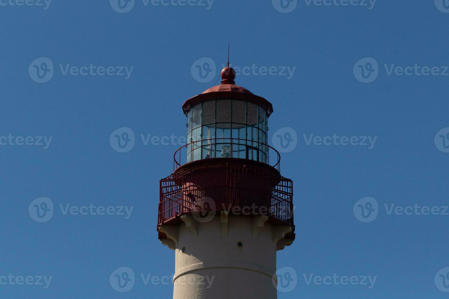 This is the top image of Capy May point lighthouse. The red metal top stands out against the white brick of the tower. photo