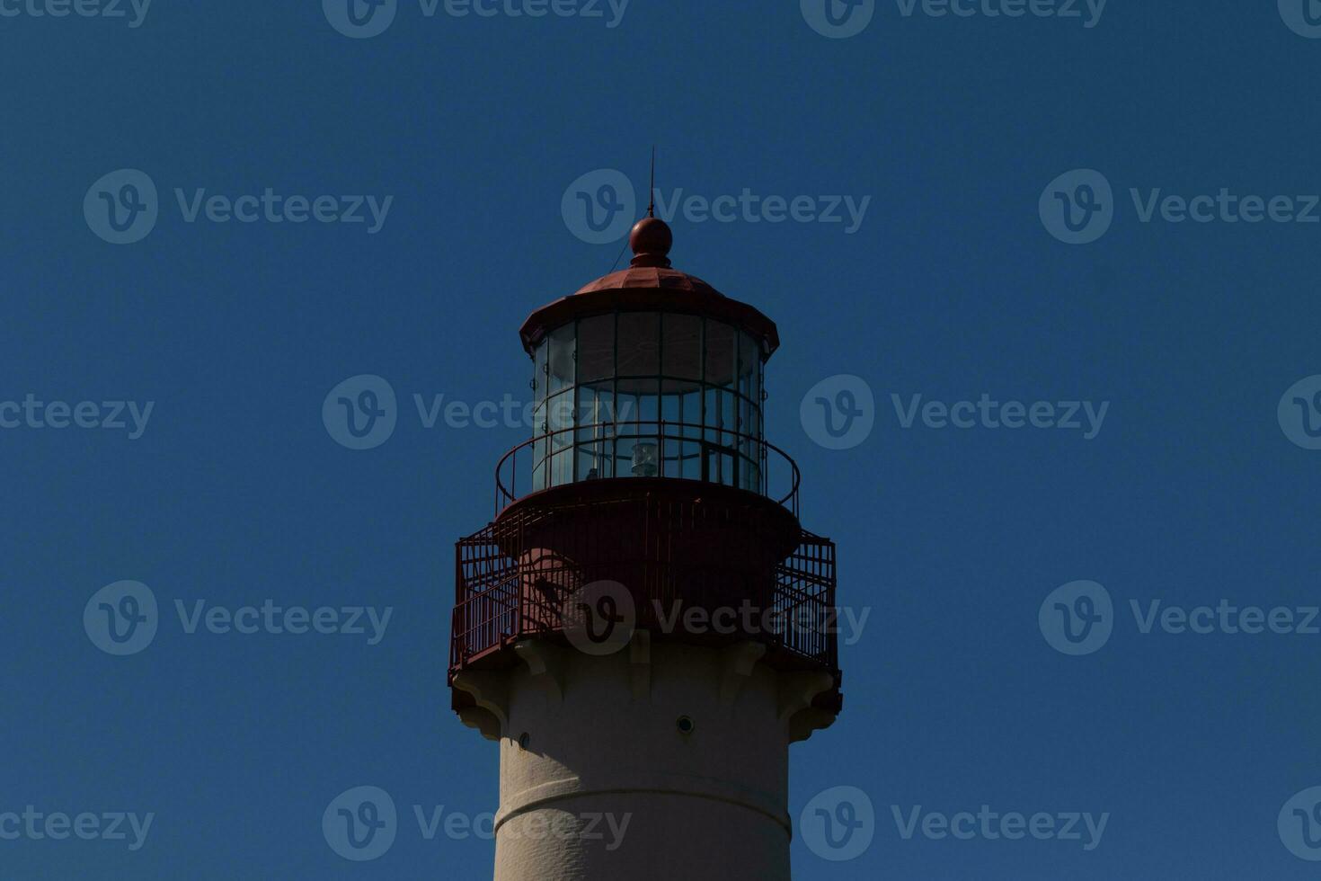 This is the top image of Capy May point lighthouse. The red metal top stands out against the white brick of the tower. photo
