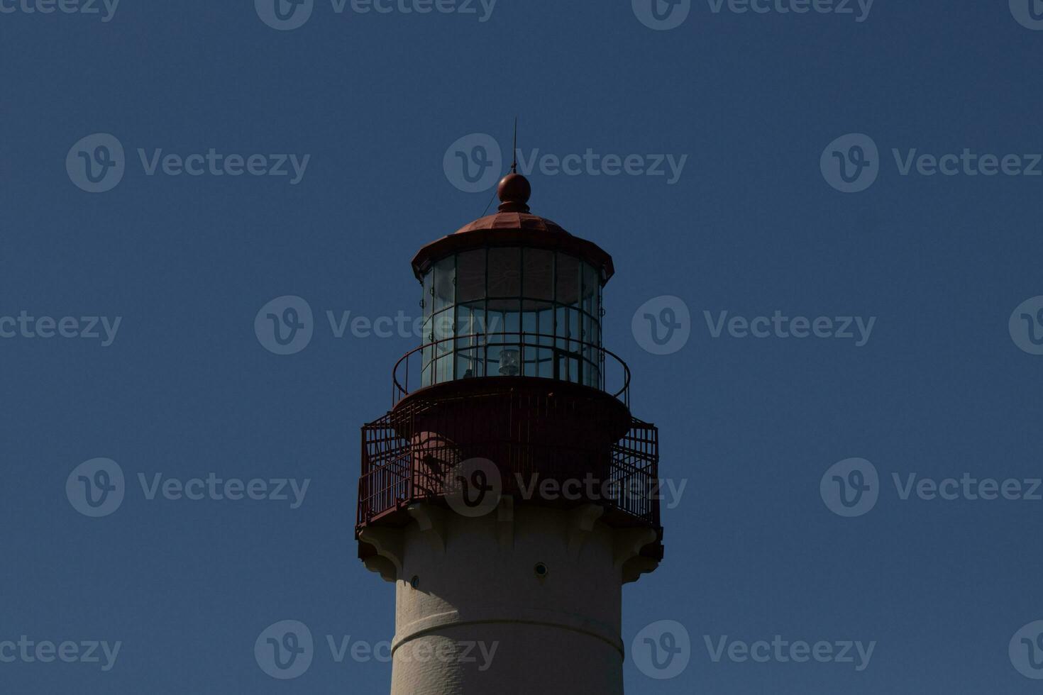 This is the top image of Capy May point lighthouse. The red metal top stands out against the white brick of the tower. photo