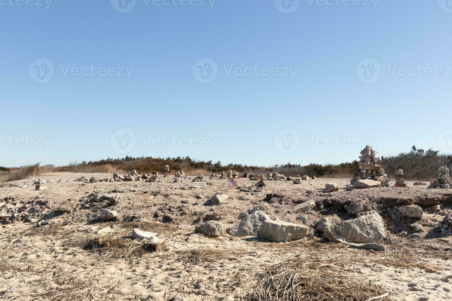 This rocky beach was at Sunset Beach in Cape May New Jersey. This beach is iconic for all the pebbles and rocks that are on it. The sand dunes in the back really add to this image. photo